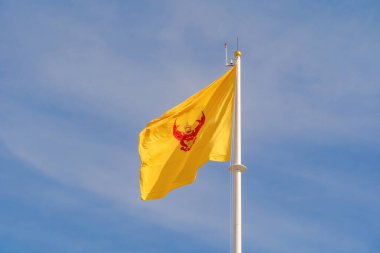 Tayland monarşisi mavi gökyüzünde rüzgarda dalgalanan kraliyet bayrağı. Resmi vatansever soyut tasarım. Garuda el sallayan işaret sembolü.