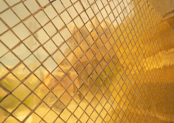 金色または金のアートグリッド正方形のモザイクタイル壁のパターンの表面のテクスチャ デザイン装飾の背景のための建築インテリア光沢のある素材のクローズアップ タイ式 — ストック写真