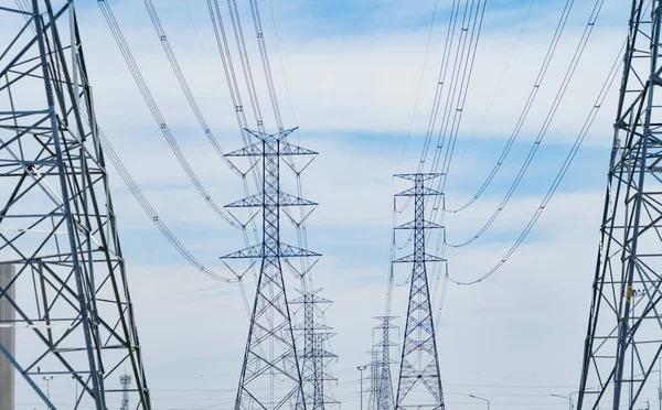 High voltage poles. Power lines on utility tower and cable wires in energy electric technology, network, and industry concept. Generator pylon. Transmission and substation.