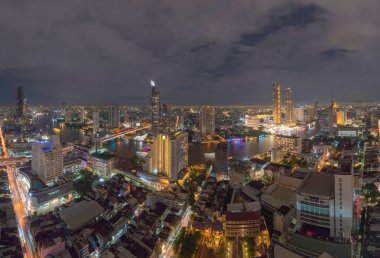 Bangkok 'taki Chao Phraya Nehri' ndeki Taksin Köprüsü 'nün havadan görüntüsü. Tayland. Finans bölgesi ve akıllı kentlerdeki iş merkezleri. Geceleri gökdelen ve yüksek binalar