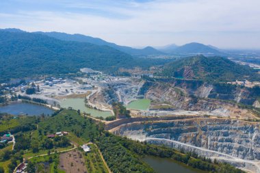 Makine kazıcı kamyonlarının hava görüntüsü dağ tepeleriyle dolu taş ocağında kömür madenciliği ya da maden cevheri kazıyor. Fabrika endüstrisinde doğa manzarası. Çevre kaynakları
