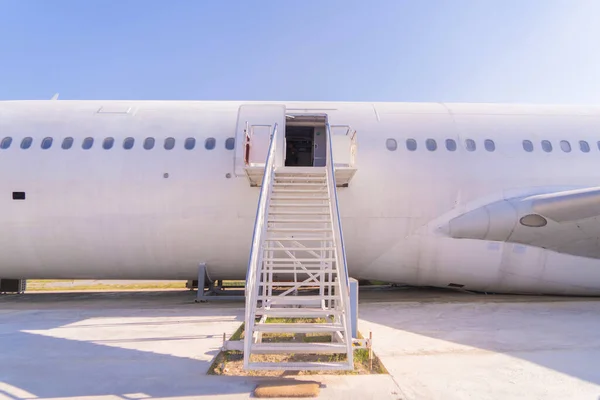 Passenger stair with boarding ramp steps. Commercial airplane, aircraft with blue sky background in travel trip and transportation concept. Flying vehicle.
