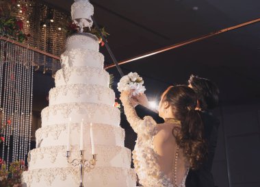 Mutlu Asyalı çift. Gelin ve damat otel salonunda düğün pastası kesiyor. Sevgi. İnsanlar evlilik kutlaması.