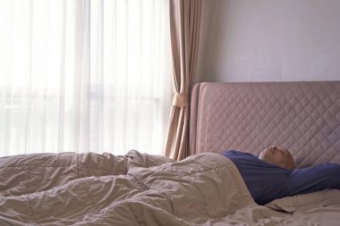 Yaşlı, uykucu zenci adam esniyor. Afrika kökenli Amerikalılar sabahın erken saatlerinde yataklarında yatıp uyuyorlar. Yaşam biçimi