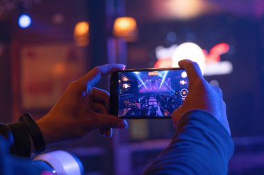 Disko barında parti müziği festivali performansı için renkli ışıklı lazer ışığı gösterisiyle sahne konserinin VDO 'sunu çekmek için elleri akıllı telefon tutuyordu. Eğlence gece hayatı. Olay.