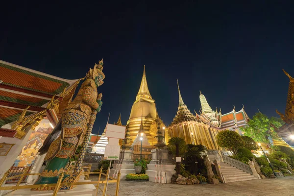 Golden pagoda at Temple of the Emerald Buddha in Bangkok, Thailand. Wat Phra Kaew and Grand palace in old town, urban city. Buddhist temple, Thai architecture. A tourist attraction at night.