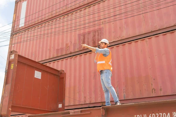 Logistic worker engineer man working in cargo container warehouse industry factory site in export, import, and transportation concept. Business people lifestyle. Distribution service.