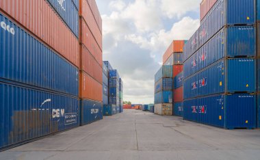 Lojistik liman depolama fabrikasında vinçle yükleme yapılan nakliye konteynır sitesi nakliye ve nakliye şirketlerinin ithalat ve ihracat mallarını üretiyor..