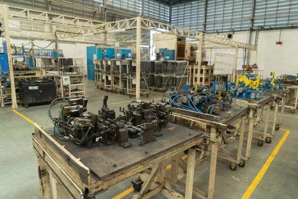 Car seat metal steel structure manufacturing factory with equipment machine engine industrial production system work, technology in operation process in industry plant. Product equipment in warehouse.