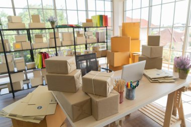 Çalışma odasındaki masada posta paketlerinin paket teslimatı ve bilgisayar dizüstü bilgisayarının iç kısmı, çevrimiçi ürünlerin satışı. Nakliye servisi. Merkez ofisteki perakende mağazası.