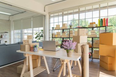 Çalışma odasındaki masada posta paketlerinin paket teslimatı ve bilgisayar dizüstü bilgisayarının iç kısmı, çevrimiçi ürünlerin satışı. Nakliye servisi. Merkez ofisteki perakende mağazası.