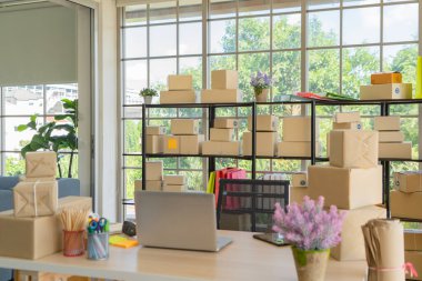 Çalışma odasındaki masada posta paketlerinin paket teslimatı ve bilgisayar dizüstü bilgisayarının iç kısmı, çevrimiçi ürünlerin satışı. Nakliye servisi. Merkez ofisteki perakende mağazası.