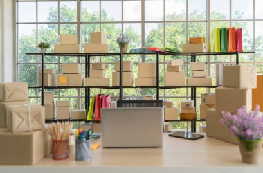 Çalışma odasındaki masada posta paketlerinin paket teslimatı ve bilgisayar dizüstü bilgisayarının iç kısmı, çevrimiçi ürünlerin satışı. Nakliye servisi. Merkez ofisteki perakende mağazası.