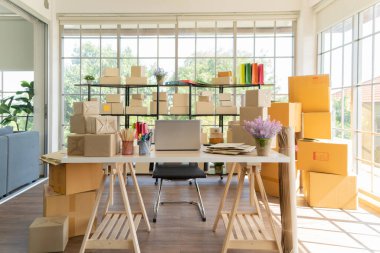 Çalışma odasındaki masada posta paketlerinin paket teslimatı ve bilgisayar dizüstü bilgisayarının iç kısmı, çevrimiçi ürünlerin satışı. Nakliye servisi. Merkez ofisteki perakende mağazası.