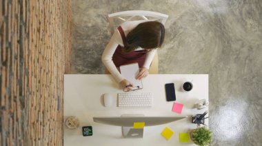 Gülümseyen Asyalı iş kadını, evden çalışan, bilgisayarlı bir kitap yazan teknoloji cihazı konsepti konferansında. Yaşam biçimi