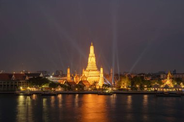 Şafak Tapınağı ya da Wat Arun lazer ışıklarıyla Chao Phraya Nehri, Bangkok, Tayland 'daki Rattanakosin Adası' nın mimarisi, şehir merkezi, silueti. Geceleri şehir merkezinde..