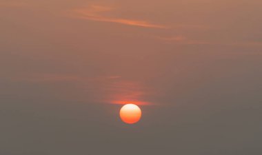Güneş batıyor. Doğa geçmişi. Alacakaranlık vakti, turuncu renkli günbatımı bulutlarıyla dramatik gökyüzü.