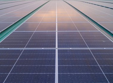 Fabrika sanayi binasının çatısındaki güneş panelleri ya da güneş pilleri. Şehir merkezindeki enerji santrali, yenilenebilir enerji kaynağı. Elektrik enerjisi için eko teknolojisi.