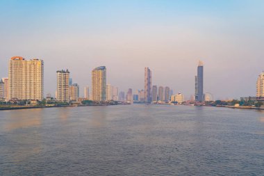 Tayland 'da Chao Phraya Nehri' nin yanındaki Bangkok City silueti. Finans bölgesi ve gökdelen binaları. Gün batımında şehir merkezi ufku.