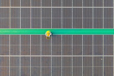 Fabrika endüstrisinde çatıda güneş panelleri ya da güneş pilleri olan mühendis ya da işçi, insanların havadan görünüşü. Enerji santrali, yenilenebilir enerji kaynağı. Elektrik enerjisi için eko teknoloji. Bakım