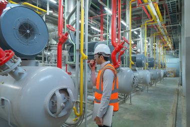 Mühendis ya da işçi, fabrikada çalışan insanlar. Soğutma kulesi ya da soğutma kulesi. Sistem çalışma makinesi. Yoğunlaştırıcı Su Kaynakları ve geri dönüş hatları. Havalandırma sıkıştırıcısı.