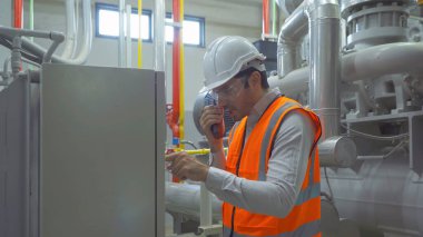 Mühendis ya da işçi, fabrikada çalışan insanlar. Soğutma kulesi ya da soğutma kulesi. Sistem çalışma makinesi. Yoğunlaştırıcı Su Kaynakları ve geri dönüş hatları. Havalandırma sıkıştırıcısı.