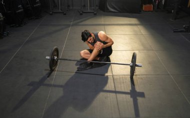 Orta Doğulu bir adam bir kazada yaralandı ve acı çekti. Jimnastik salonunda kas gücü antrenmanı. Spor malzemeleriyle içeride egzersiz yap. Atletik. İnsanların yaşam tarzı. Ağrı ya da kramplar.