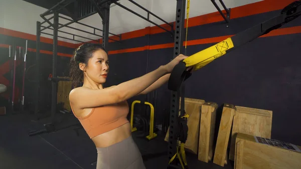 アジアの女性は心臓のためのTrxの懸濁液を行う ジムフィットネスセンタークラブでの筋力トレーニングワークアウト スポーツ用品を使って屋内で運動する アスレチック 人々の暮らし — ストック写真
