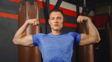 Beyazların güçlü portresi boks spor klubünde vücut geliştirme merkezinde kas pozu veren güçlü bir adam. Spor aletlerini çalıştırın. İnsan yaşam tarzı.