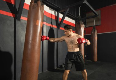 Beyazların güçlü kum torbaları, boks spor kulübü antrenmanlarında spor salonunda dövüş yumrukları. Spor aletlerini çalıştırın. İnsan yaşam tarzı.