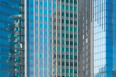 Ofis binalarının pencereleri. Şehir merkezi Dubai 'de cam mimari ön cephe tasarımı. Mavi gökyüzü ile finans bölgesinde şehir.
