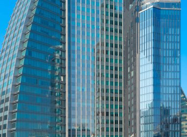 Ofis binalarının pencereleri. Şehir merkezi Dubai 'de cam mimari ön cephe tasarımı. Mavi gökyüzü ile finans bölgesinde şehir.