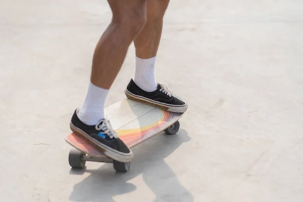 Man foot playing skateboard sweeping turns on surf skate on street road, control motion balancing movement extreme outdoor activity with skills. People lifestyle recreation.