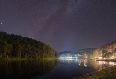 Samanyolu olan orman ağaçları ve geceleri Pang Oung 'da göl veya nehirde yıldızlar seyahat ve çevre kavramında. Mae Hong Son, Tayland 'da doğa manzarası.