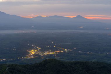 Gün batımında sisli orman ağaçlarının ve yeşil dağ tepelerinin havadan görünüşü. Doğa manzarası arka planı, Tayland.