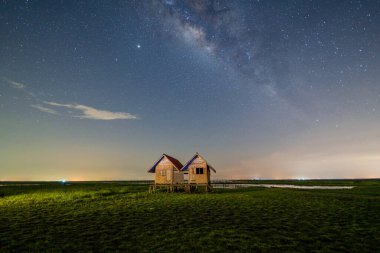 Twin House building at Ekachai Bridge, Phatthalung at night with milky way and stars, Thailand. Thai architecture at Tourist attraction landmark. Travel on holiday vacation concept. clipart