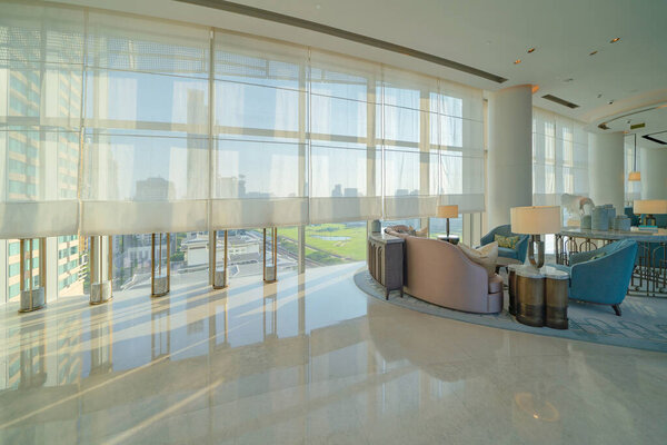 Внутри современного вестибюля, входа и приема, зона ожидания с видом на город на открытом воздухе, в помещении.