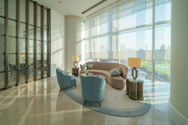 Внутри современного вестибюля, входа и приема, зона ожидания с видом на город на открытом воздухе, в помещении.