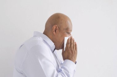 Yaşlı siyahi iş adamı. Hasta Afrikalı Amerikalı öksürüyor ya da hapşırıyor. Tıbbi tedavi görüyor ve beyazın üzerinde izole edilmiş bir sağlık hizmeti veriyor. Coronavirus. İnsan yaşam tarzı.