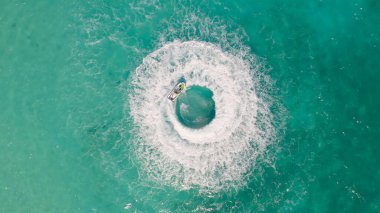 Jet ski ya da teknenin havadan görünüşü deniz okyanusu turkuaz suyuna şekil veriyor. Yaz mevsiminde maceraperest eğlence aktiviteleri. Yaşam biçimi