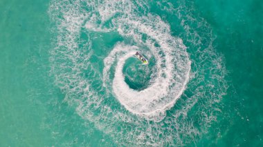 Jet ski ya da teknenin havadan görünüşü deniz okyanusu turkuaz suyuna şekil veriyor. Yaz mevsiminde maceraperest eğlence aktiviteleri. Yaşam biçimi