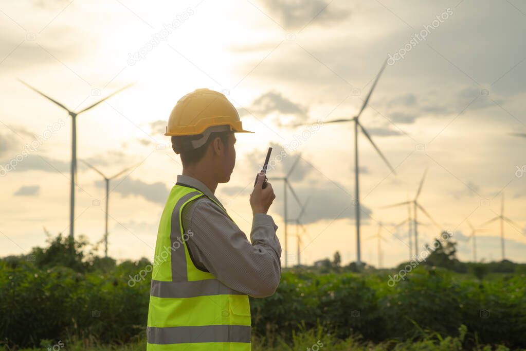 Portrait of Asian windmill engineer man, worker working on site at wind turbines field or farm, renewable clean energy source. Eco technology for electric power. industry nature environment. People