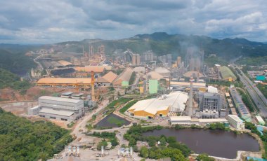 Kömür Santrali 'nin bacadan çıkan dumanlı ve zehirli havalı havası. Fabrika endüstrisi. Enerji veya çevre kirliliği konsepti ile elektrik kulesi doğa orman ağaçları manzara.