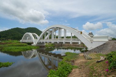 Chomphu Beyaz Köprüsü, Lamphun, Tayland gölü veya nehri, orman ağaçları ve yeşil dağ tepesi. Doğa manzarası. Turistik bölge simgesi.