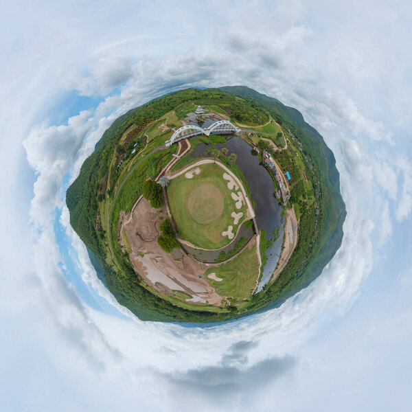 Little planet 360 degree sphere. Panorama of aerial view of Tha Chomphu White Bridge, Lamphun, Thailand with lake or river, forest trees and green mountain hill. Nature landscape.