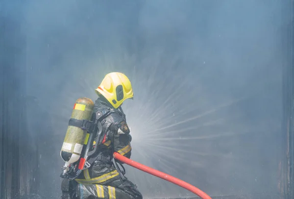 Firefighter Fireman Uniform Using Water Fire Hose Hot Burning Fire — 图库照片