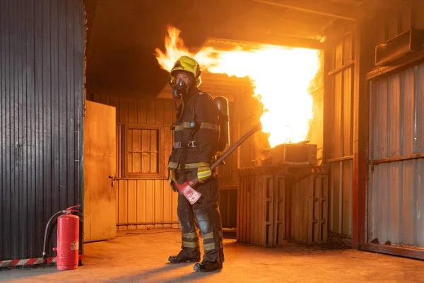 消防士や消防士は コンテナ内の熱い燃焼火災や危険な煙 緊急事故救助に対して水火ホースを使用して制服を着ています ヒーロー — ストック写真