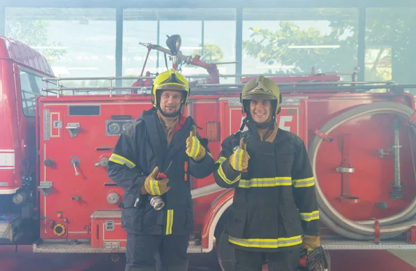 Portrait of a group of caucasian firefighters or firemen team with uniform, working on their career. An emergency accident rescue. People. Hero teamwork with a fire truck car. Service job