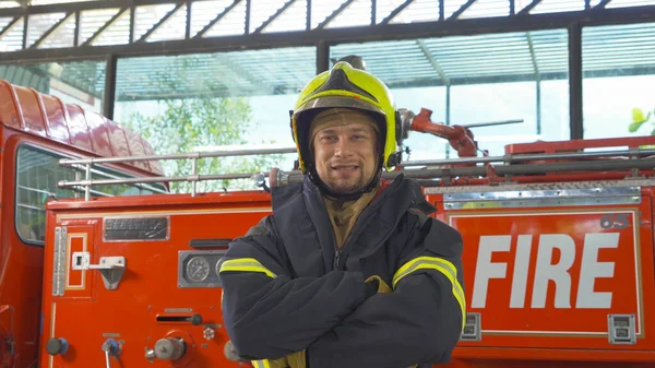 Portrait of a caucasian firefighter or fireman man with uniform, working on their career. An emergency accident rescue. People. Hero with a fire truck or ambulance car. Service job