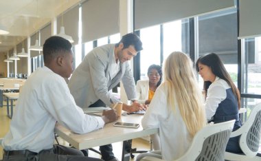 Çok ırklı iş adamlarından oluşan bir grup toplanıyor, iletişim kuruyor, belgeleri tartışıyor ve ofis seminerindeki bir toplantı odasında çalışıyor, iş arkadaşlarıyla fikir paylaşıyor. İnsanların yaşam tarzı. Şirket takım çalışması